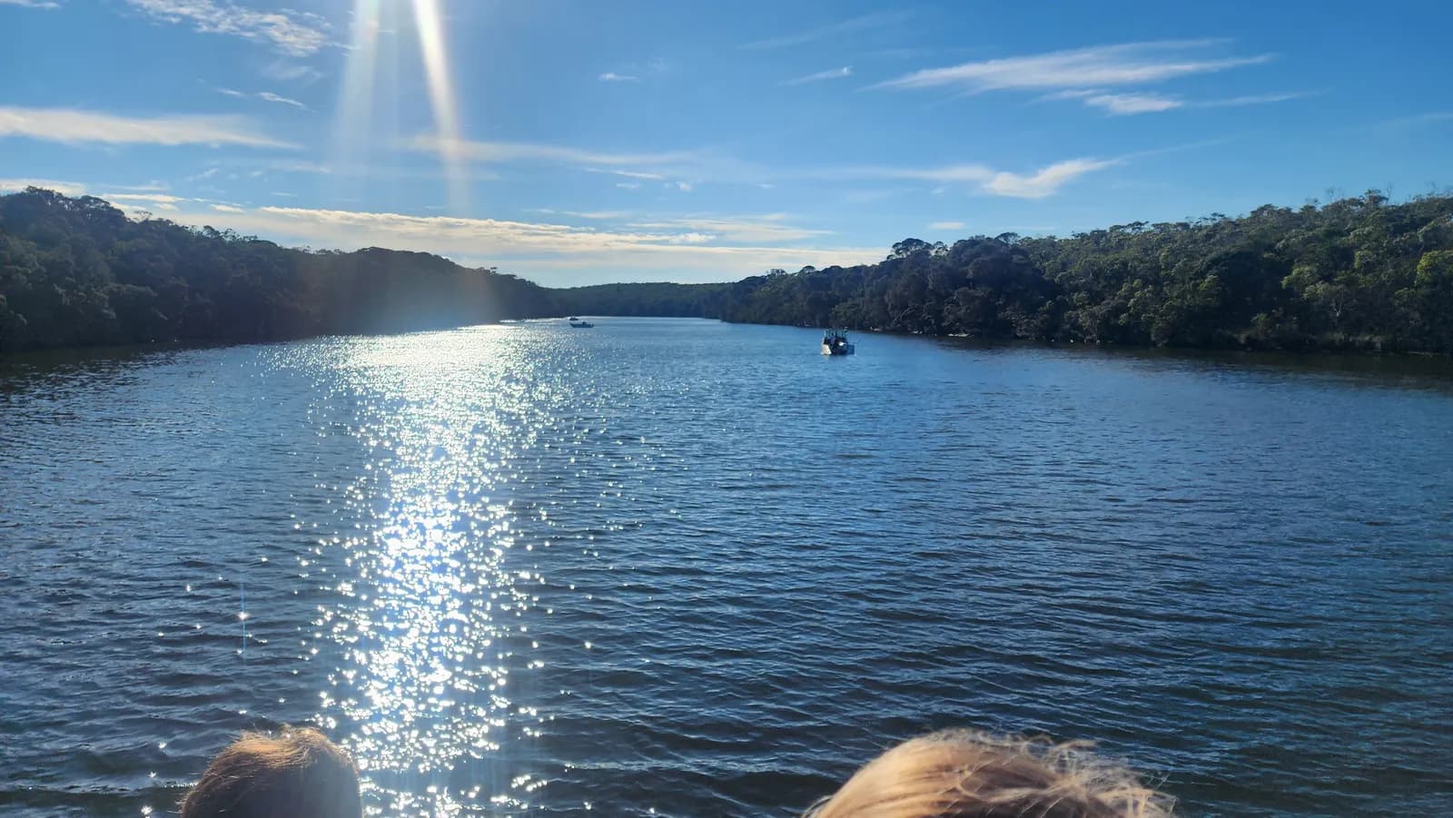 The view forward over the bow of MV Mini Munya, sun glittering on the water ahead