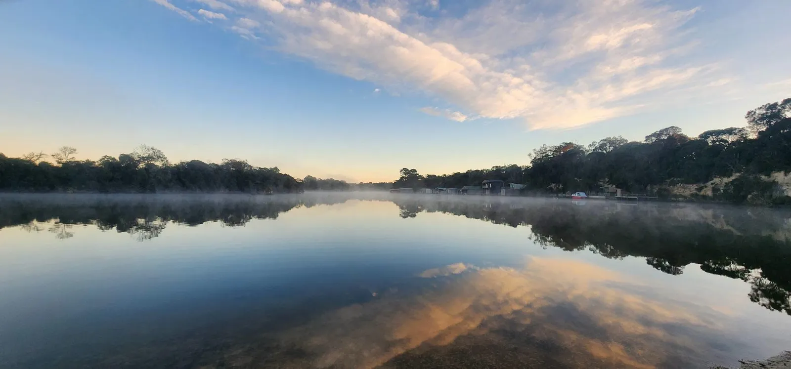 Morning mist lying on the Glenelg River with cloud reflected in the surface