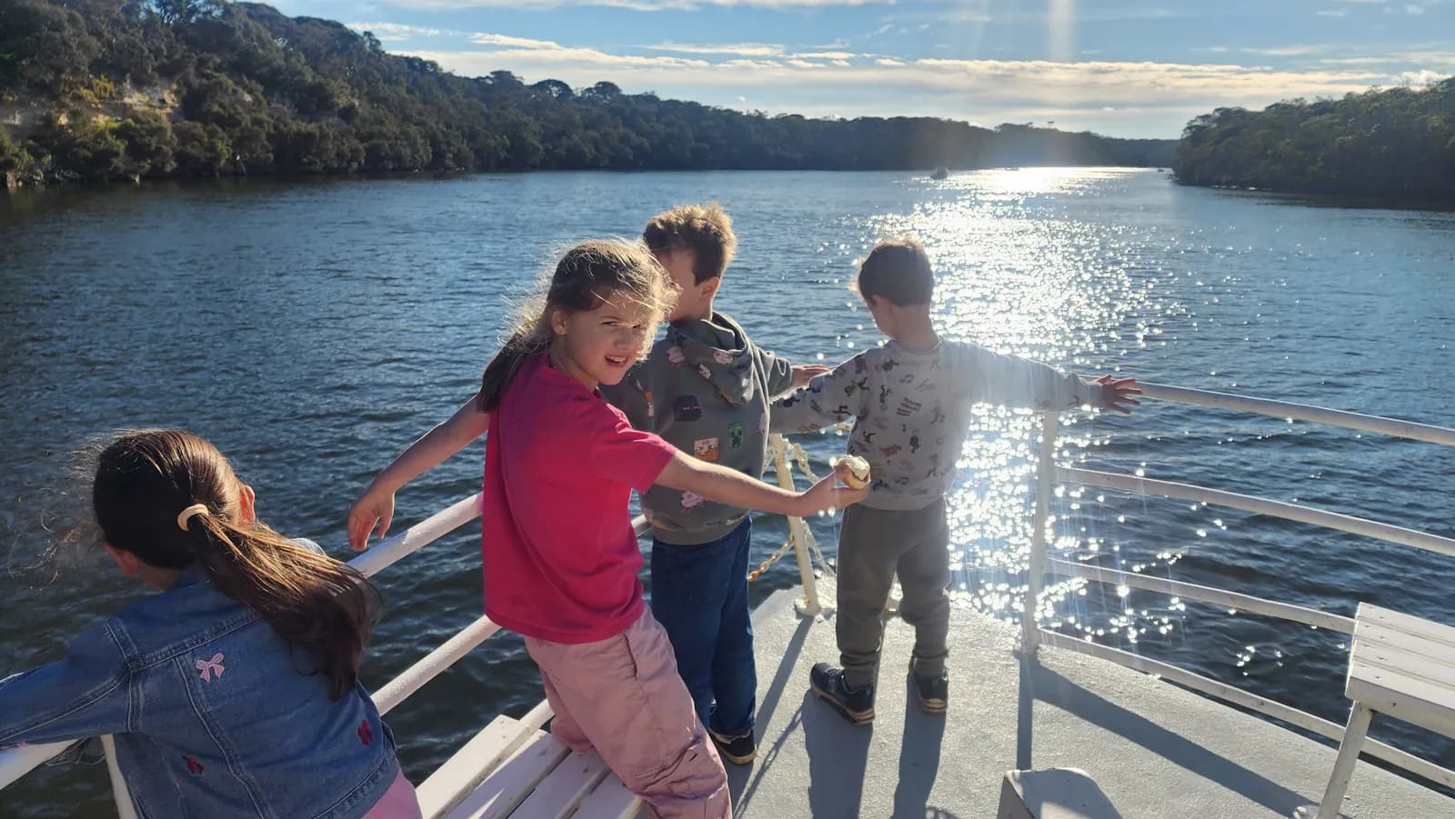 Children playing on the foredeck of MV Mini Munya in the winter sun
